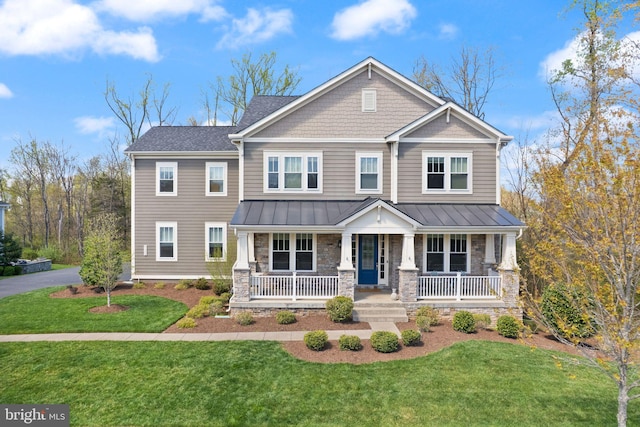 craftsman-style home featuring a front yard, stone siding, metal roof, covered porch, and a standing seam roof