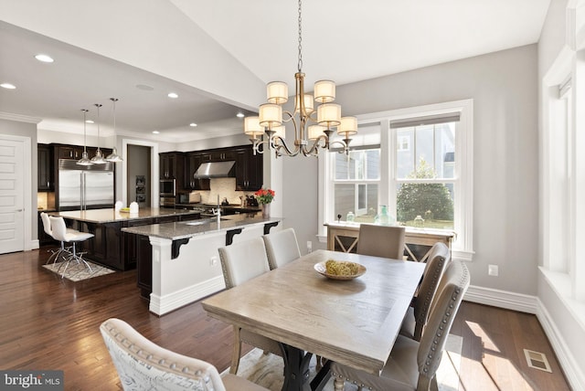 dining space with a notable chandelier, ornamental molding, dark wood finished floors, recessed lighting, and vaulted ceiling