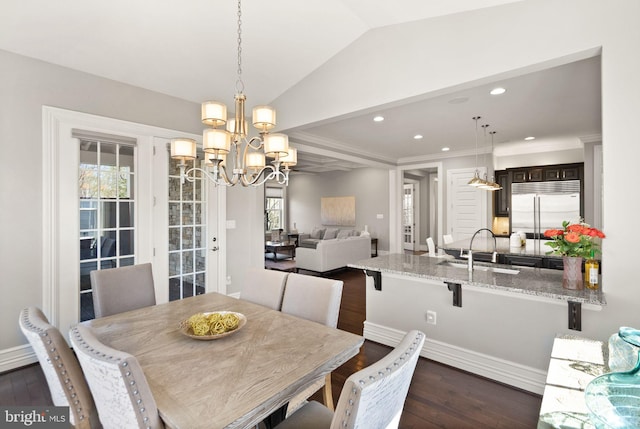 dining room featuring an inviting chandelier, dark wood finished floors, recessed lighting, lofted ceiling, and baseboards