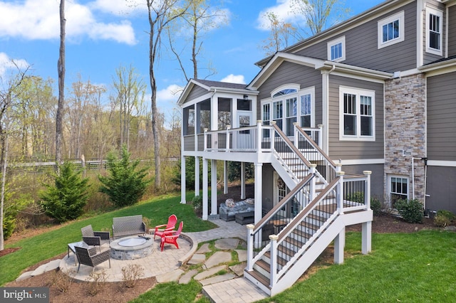 back of property with a patio, stairway, a fire pit, a sunroom, and a lawn