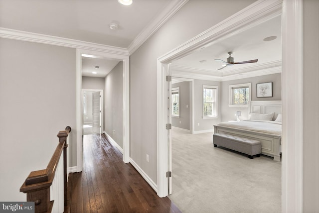 corridor featuring an upstairs landing, hardwood / wood-style flooring, baseboards, and ornamental molding