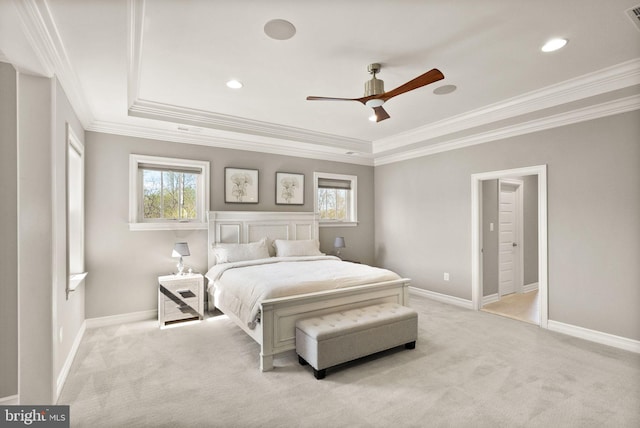bedroom with a tray ceiling, light carpet, and multiple windows