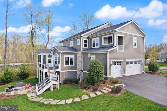 view of front of property featuring a garage, a front yard, a fire pit, stairs, and driveway
