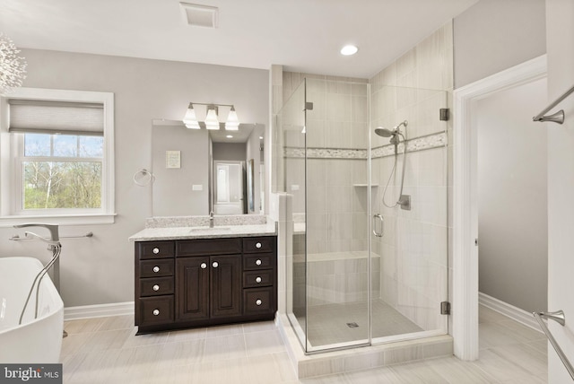 bathroom featuring a freestanding tub, vanity, visible vents, a stall shower, and baseboards