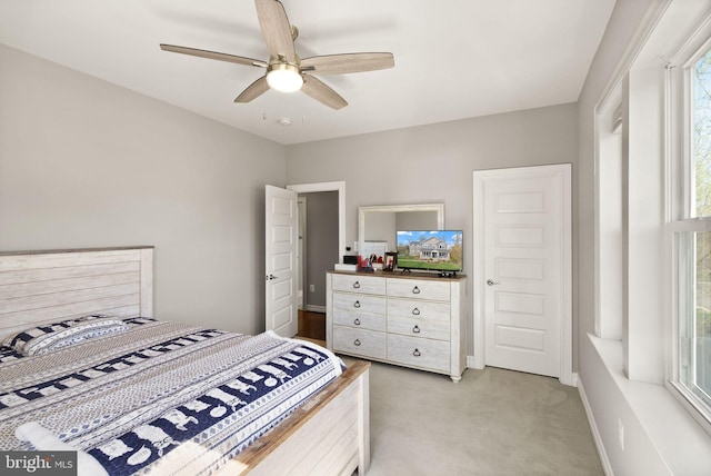 bedroom featuring light carpet, baseboards, and a ceiling fan