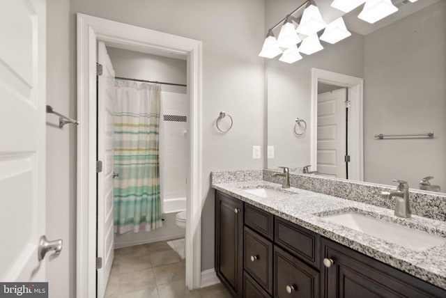 full bath featuring toilet, double vanity, a sink, and tile patterned flooring