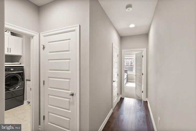 hallway with wood-type flooring, baseboards, and washer / dryer