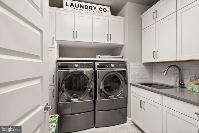 laundry area featuring a sink, cabinet space, and washing machine and dryer