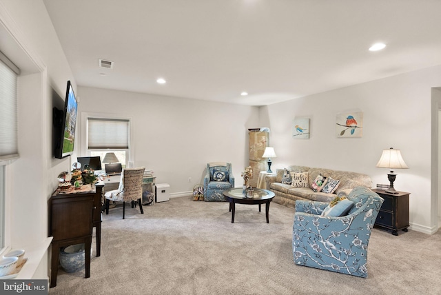 carpeted living area featuring baseboards, visible vents, and recessed lighting