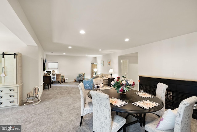 dining area featuring light carpet, baseboards, a barn door, and recessed lighting