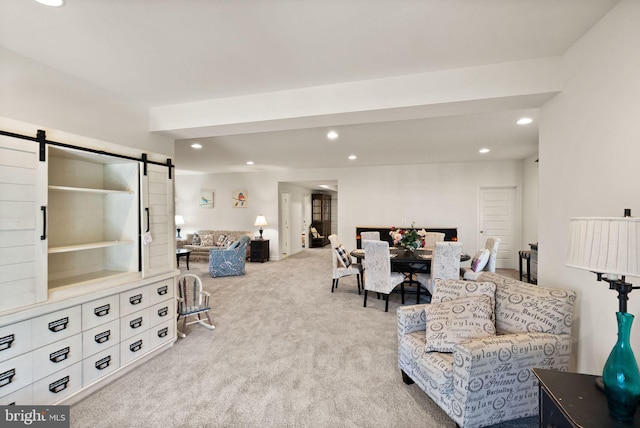 carpeted living area with recessed lighting and a barn door