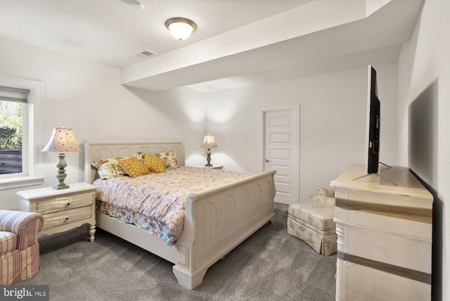 bedroom with dark colored carpet and visible vents