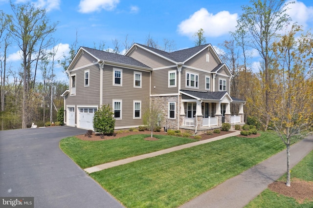 craftsman-style home with stone siding, a front lawn, aphalt driveway, a porch, and a garage