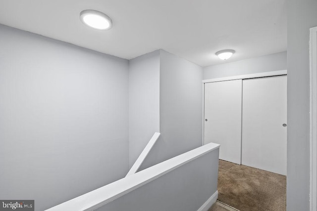 corridor featuring carpet and an upstairs landing