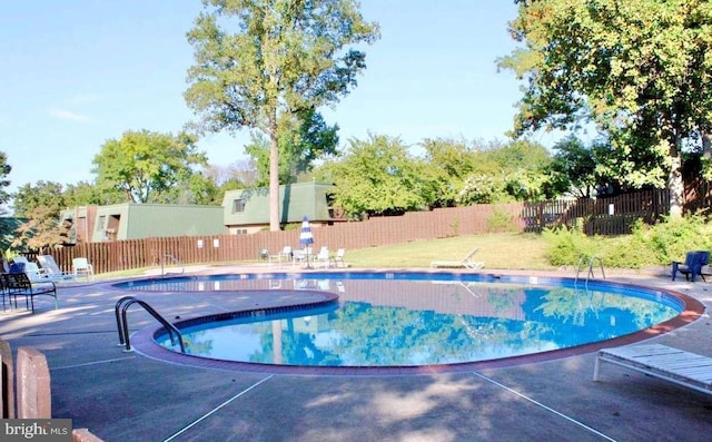 community pool featuring fence and a patio area