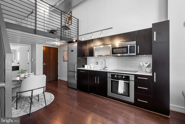 1401 R St NW Unit 304, Washington, DC 20009 - kitchen featuring appliances with stainless steel finishes, light countertops, baseboards, a sink, and a high ceiling