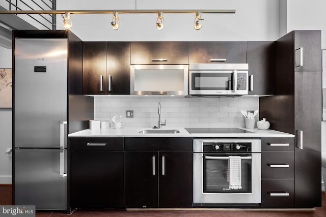 1401 R St NW Unit 304, Washington, DC 20009 - kitchen with light countertops, stainless steel appliances, decorative backsplash, and a sink