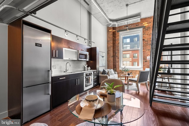 1401 R St NW Unit 304, Washington, DC 20009 - kitchen featuring appliances with stainless steel finishes, tasteful backsplash, dark wood finished floors, light countertops, and a sink