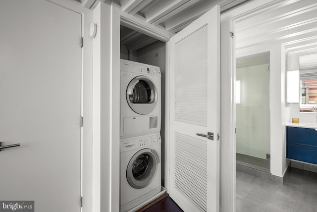 1401 R St NW Unit 304, Washington, DC 20009 - washroom featuring tile patterned flooring, stacked washer and clothes dryer, and laundry area