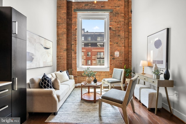 1401 R St NW Unit 304, Washington, DC 20009 - living area featuring baseboards, wood finished floors, and brick wall