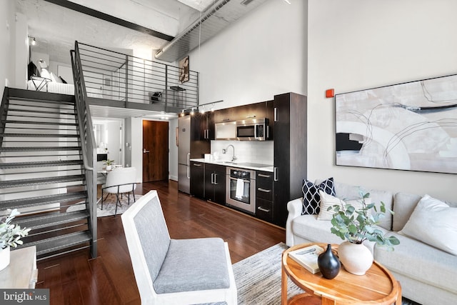 1401 R St NW Unit 304, Washington, DC 20009 - living area featuring dark wood-type flooring, a towering ceiling, and stairway