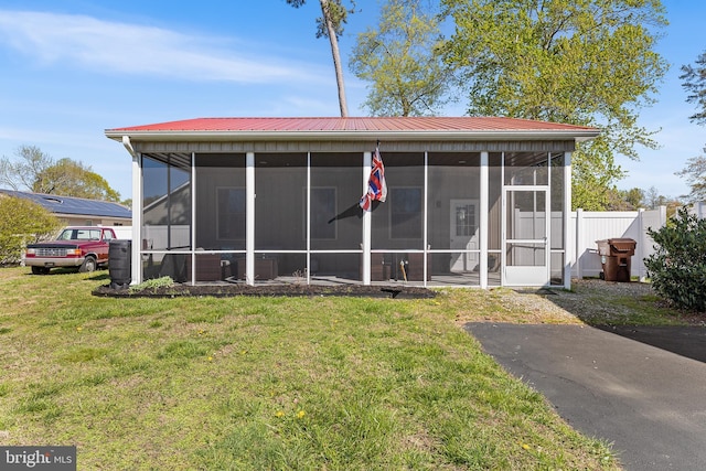 129 Prince Georges Dr, Dagsboro, DE 19939 - rear view of house with a sunroom, fence, metal roof, and a lawn