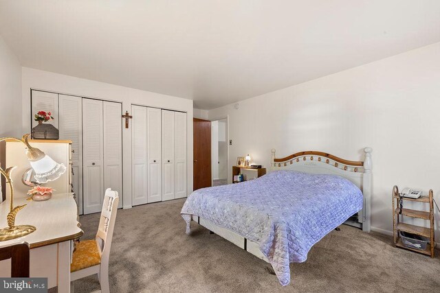 bedroom featuring two closets and carpet flooring