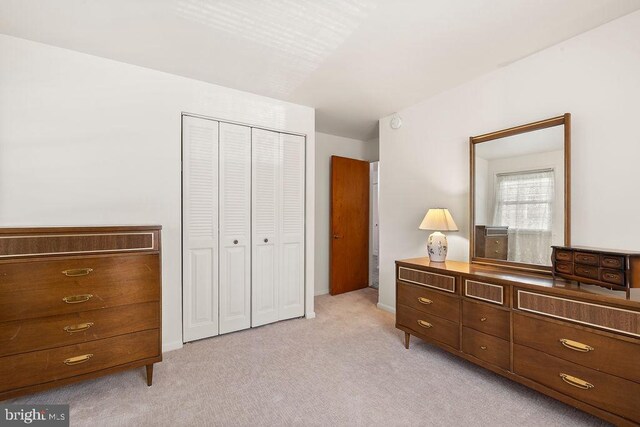 bedroom featuring a closet and light colored carpet