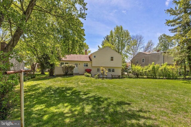 rear view of house featuring a yard