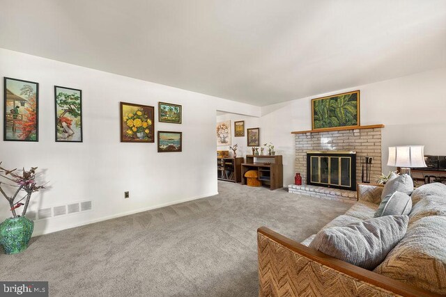 living area featuring carpet floors, baseboards, visible vents, and a brick fireplace