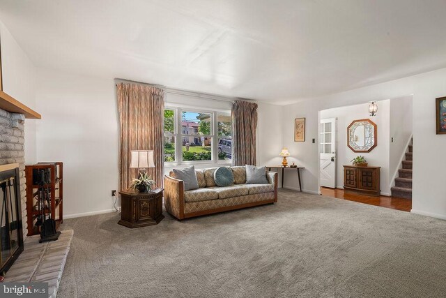 living room with stairs, baseboards, carpet, and a fireplace