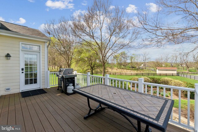 wooden deck featuring outdoor dining area, fence, and grilling area