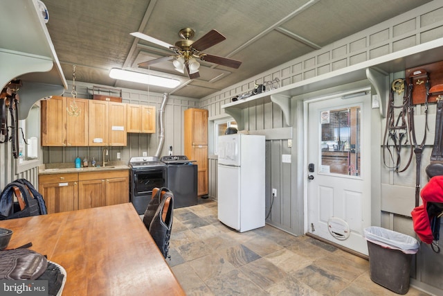 kitchen with separate washer and dryer, freestanding refrigerator, stone finish flooring, and ceiling fan