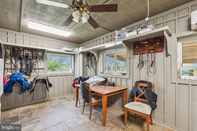 dining area with a ceiling fan and stone finish floor