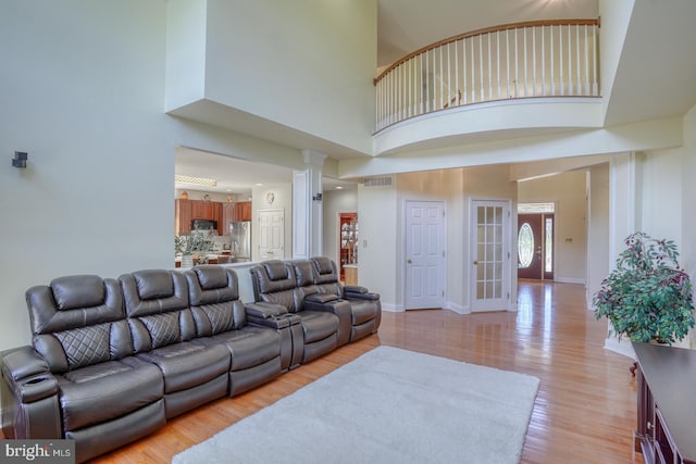 113 Anna Ct, Middletown, DE 19709 - living room featuring light wood finished floors, baseboards, a towering ceiling, ornate columns, and visible vents