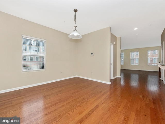 unfurnished room featuring baseboards and wood finished floors
