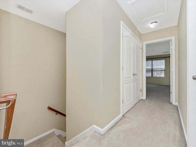 hall featuring an upstairs landing, visible vents, light colored carpet, and baseboards
