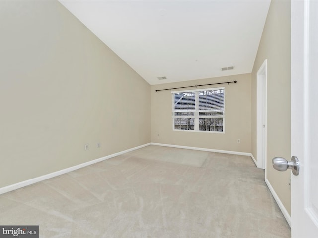 unfurnished room with light carpet, visible vents, baseboards, and lofted ceiling