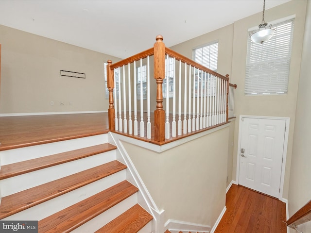 stairway with baseboards and wood finished floors