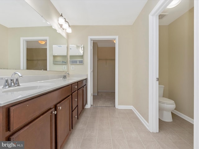 bathroom featuring baseboards, a sink, and toilet