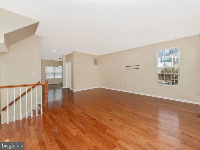 spare room featuring visible vents, a wealth of natural light, light wood-style floors, and baseboards