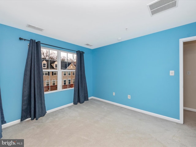 empty room featuring visible vents, baseboards, and carpet floors