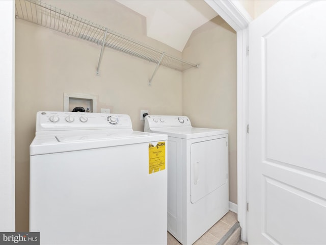 clothes washing area with laundry area, light tile patterned floors, and washer and clothes dryer