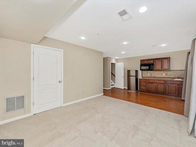 unfurnished living room with visible vents, recessed lighting, and carpet flooring