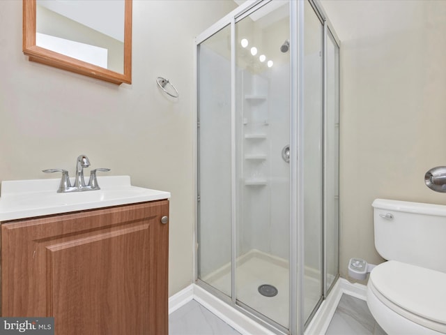 full bath featuring a shower stall, vanity, baseboards, and toilet
