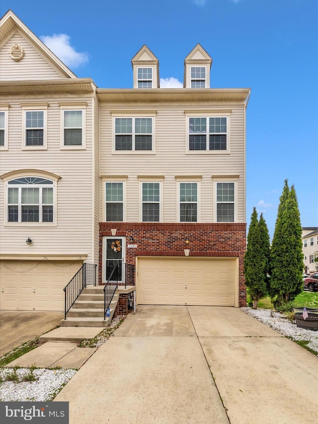 view of front of house featuring an attached garage, driveway, and brick siding
