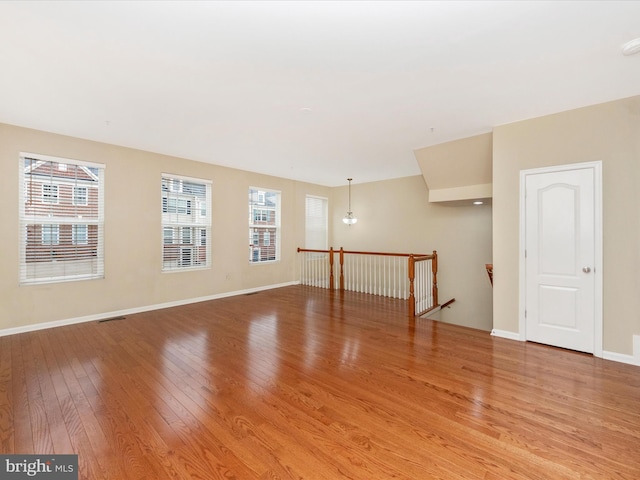 spare room with visible vents, baseboards, and light wood finished floors