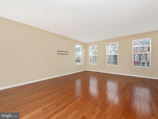unfurnished room featuring baseboards and hardwood / wood-style floors
