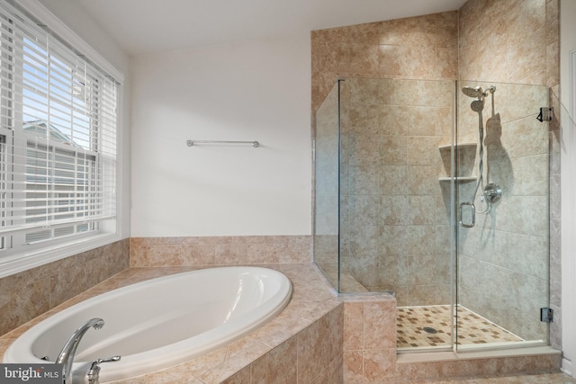 full bathroom featuring a shower stall and a bath