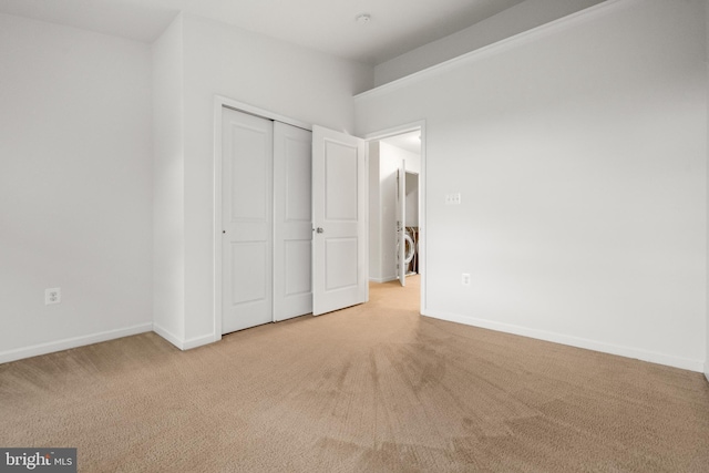 unfurnished bedroom featuring carpet flooring, a closet, and baseboards
